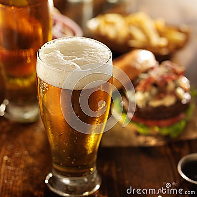 Cold beer with foamy head and burgers Stock Photo