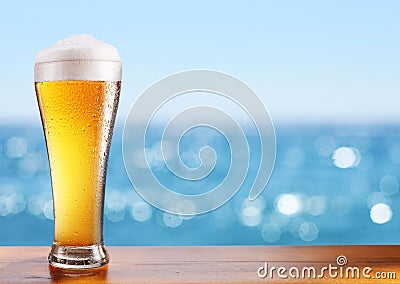 Cold beer glass on the bar table at the open-air cafe. Stock Photo