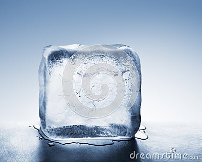 Cold blue ice block melting into water puddle Stock Photo