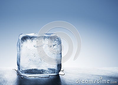 Cold blue ice block melting into water puddle Stock Photo