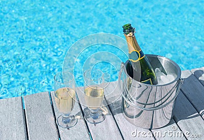 Cold champagne bottle in ice bucket and two glasses of champagne on the deck by the bottle in bucket and two glasses of champagne Stock Photo