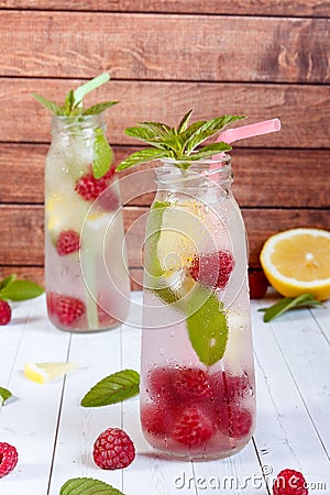 Cold cocktail with raspberries, lemon and mint. Wooden background Stock Photo