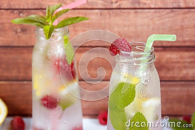 Cold cocktail with raspberries, lemon and mint. Wooden background Stock Photo