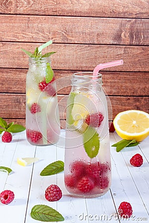 Cold cocktail with raspberries, lemon and mint. Wooden background Stock Photo