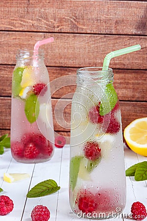 Cold cocktail with raspberries, lemon and mint. Wooden background Stock Photo