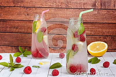 Cold cocktail with raspberries, lemon and mint. Wooden background Stock Photo