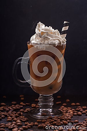 Cold coffee with ice and milk in a glass and whipped cream on top Stock Photo