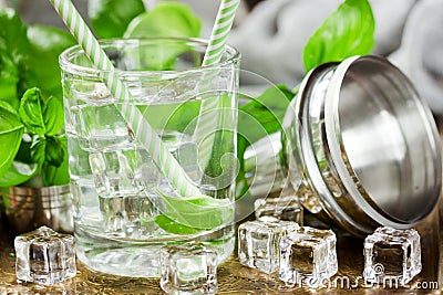 Cold drink with ice cubes and basil leaves in a glass Stock Photo