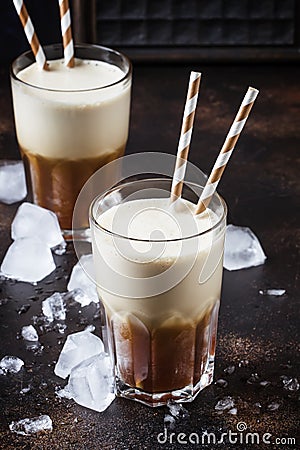 Cold frappe coffee with ice and foam in large glasses on brown b Stock Photo