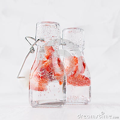 Cold fresh fruit beverages of ripe strawberry with soda water, bubbles on simple soft bright white background, square. Stock Photo