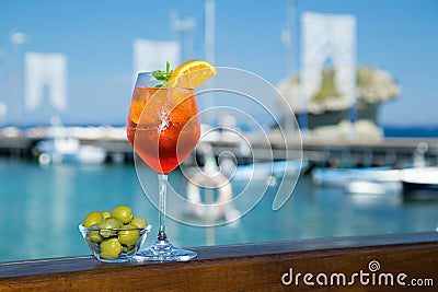 Cold glass of aperol spritz near the sea and boats Stock Photo