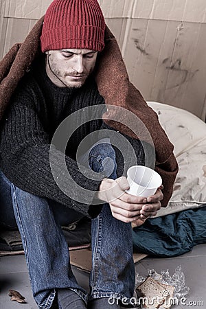 Cold and homeless man begs for money Stock Photo