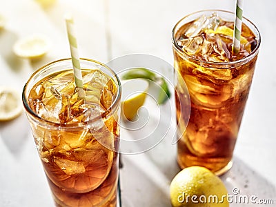 Cold iced tea with straws and lemon slices in summer sun. Stock Photo