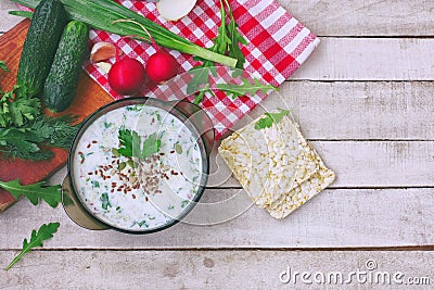 Cold kefir soup in glass bowl with spicy herbs, cucumber, radish Stock Photo