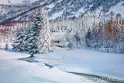 Cold morning scene of frozen rive and white wooden house on backgroundr. Stock Photo