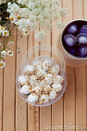 Cold purple anchan cocktail with antioxidants, straw reed and vegan gluten free nuts dessert in a disposable cup Stock Photo