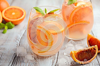 Cold refreshing drink with blood orange slices in a glass on a wooden background. Stock Photo