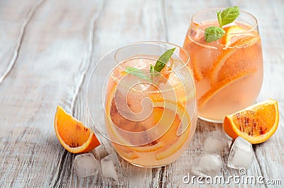 Cold refreshing drink with blood orange slices in a glass on a wooden background. Stock Photo