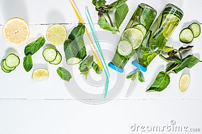 Cold and refreshing infused detox water with lime, mint and cucumber in a bottle on white wood background. Copyspace and Stock Photo