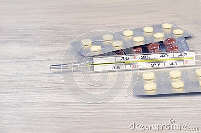 Cold thermometer pills. Flu cure, remedy for convalescence. Photo on a wooden background Stock Photo