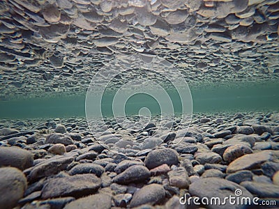 Cold underwater river bed with perfect reflection on surface tension Stock Photo