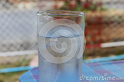 Cold Water on Wood Table. glass of Cool fresh drink with ice Stock Photo