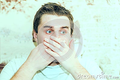 A cold young man sneezes into Stock Photo