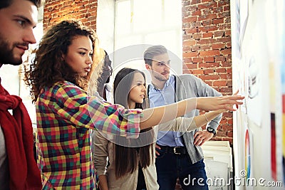 Collaboration is a key to best results. Group of young modern people in smart casual wear planning business strategy Stock Photo