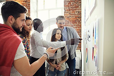 Collaboration is a key to best results. Group of young modern people in smart casual wear planning business strategy Stock Photo