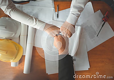 Collaboration team of young man and asian woman engineers, architects fist bump show strength teamwork after meeting,discussing, Stock Photo