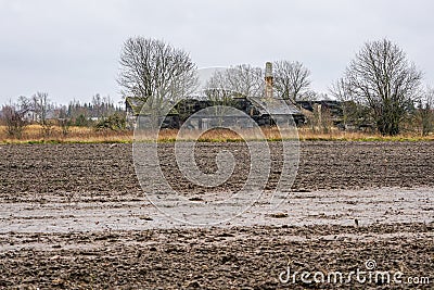 Collapsed country house on the edge of a plowed field Stock Photo