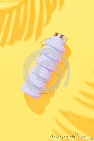 Collapsible reusable lilac water bottle on yellow background. Sustainability, eco-friendly lifestyle Stock Photo