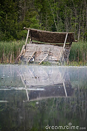 Collapsing Duck Blind Reflected In The River Stock Photo