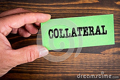Collateral. Text on green sticky note. Wood texture background Stock Photo