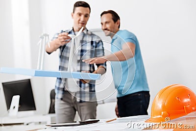 Colleagues discussing the height of wind turbine models Stock Photo