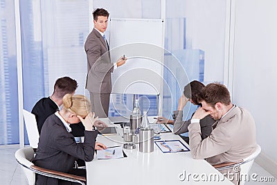 Colleagues getting bored during business presentation Stock Photo