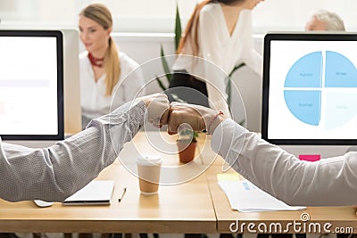 Colleagues giving fist bump, corporate teamwork concept, close u Stock Photo