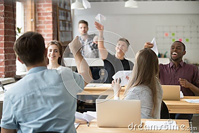 Colleagues launching paper planes in office Stock Photo