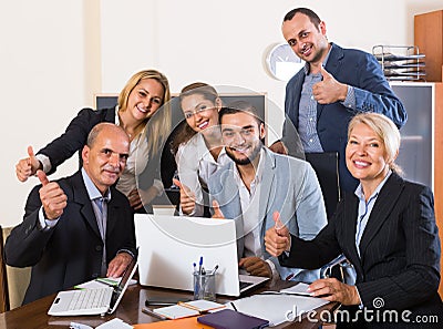 Colleagues looking at laptop and smiling Stock Photo