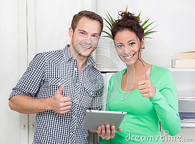 Colleagues showing alright with thumbs up and tablet pc Stock Photo