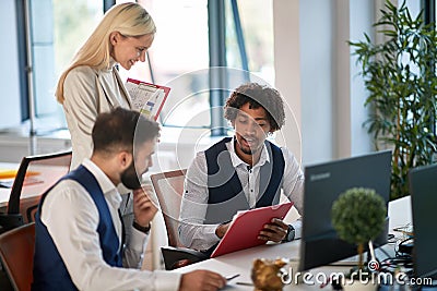 Colleagues showing plan, report, data, stats, content on paper to a female boss. conversation, multiethnic, boss, employee, Stock Photo