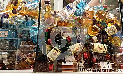 collectible mini bottles of alcohol at the duty free market shop. Little alcohol drinks in glass box. Editorial Stock Photo