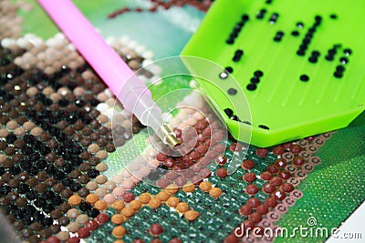 Collecting diamond embroidery, diamond mosaic. Colored crystals Stock Photo