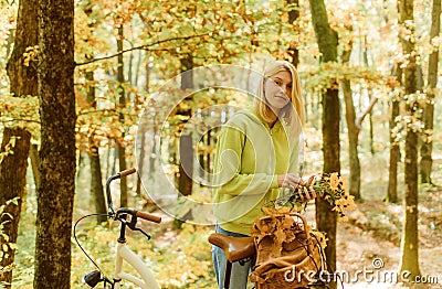 Collecting forest flowers. Blonde enjoy relax forest. Autumn bouquet. Warm autumn. Girl with bicycle and flowers. Woman Stock Photo