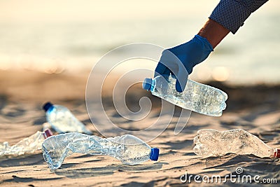 Collecting plastic bottles on sea beach. Cleaning environmental pollution Stock Photo