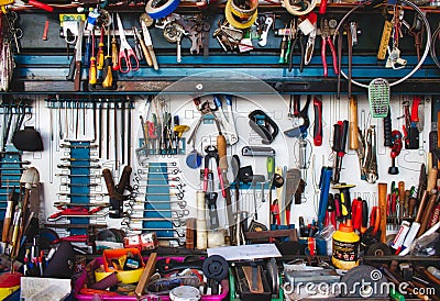 A collection of assorted tools hanging on the wall with a work bench Editorial Stock Photo