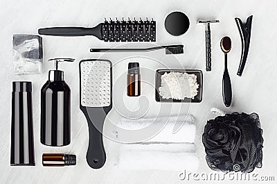 Collection of black and silver luxury glossy cosmetic and accessories for bathing, skin and body care on white wood board. Stock Photo