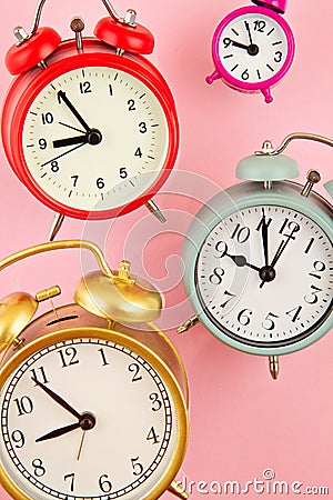 Collection of bright colorful alarm clocks over the pink background Stock Photo