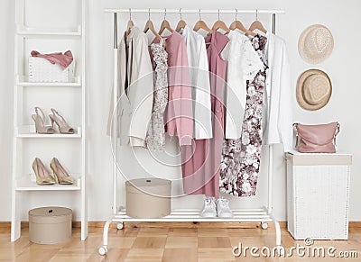 Collection of female clothes hanging on rack in dressing room Stock Photo