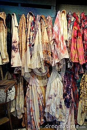 Collection of Hanging Vintage Tie Dye, Plaid and Checkered Shirts Stock Photo